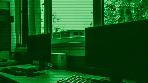 Modern computers on a desk next to a window
